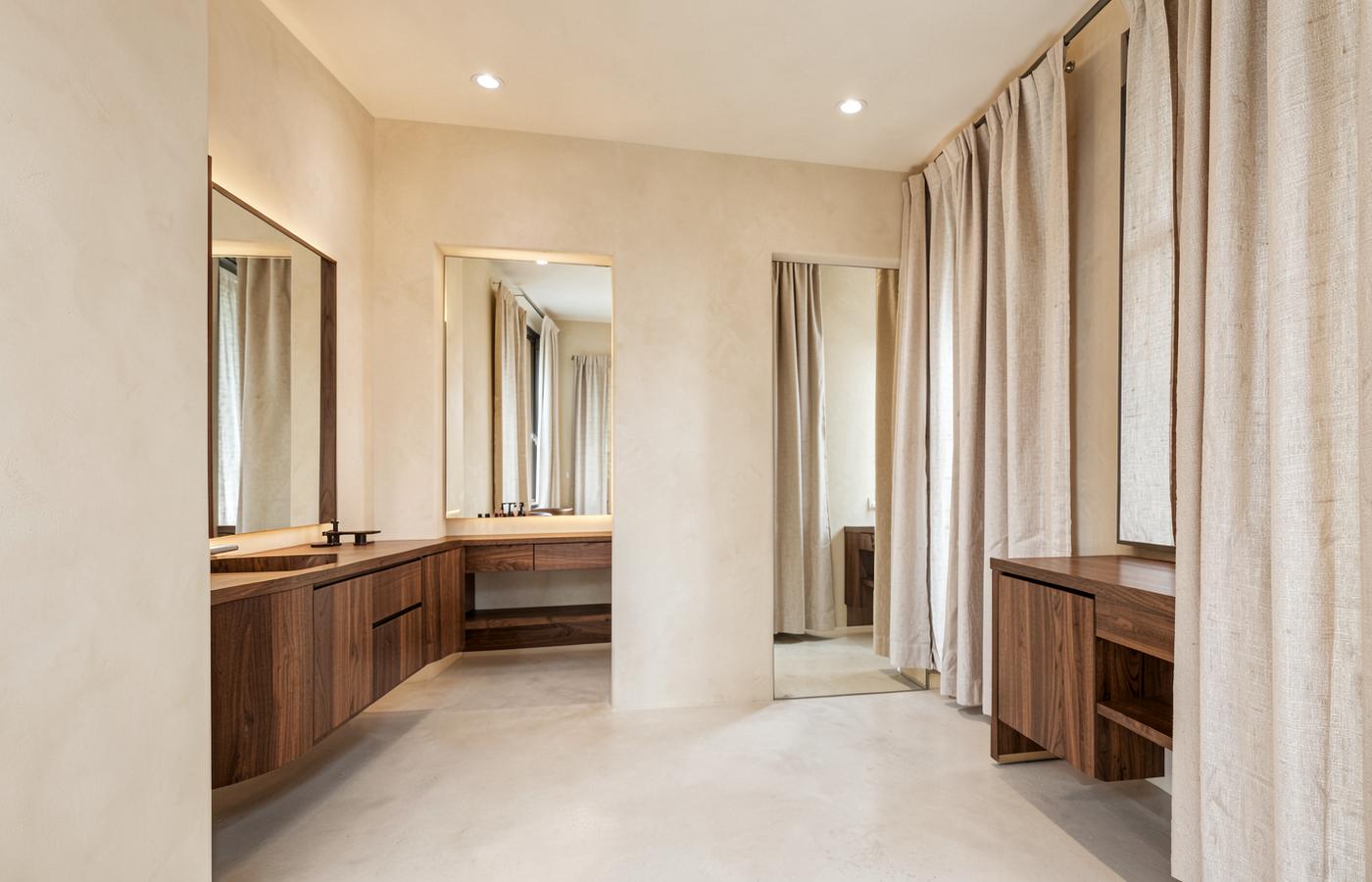 Interno di un salone contemporaneo con pareti in calce, legno di noce e specchi