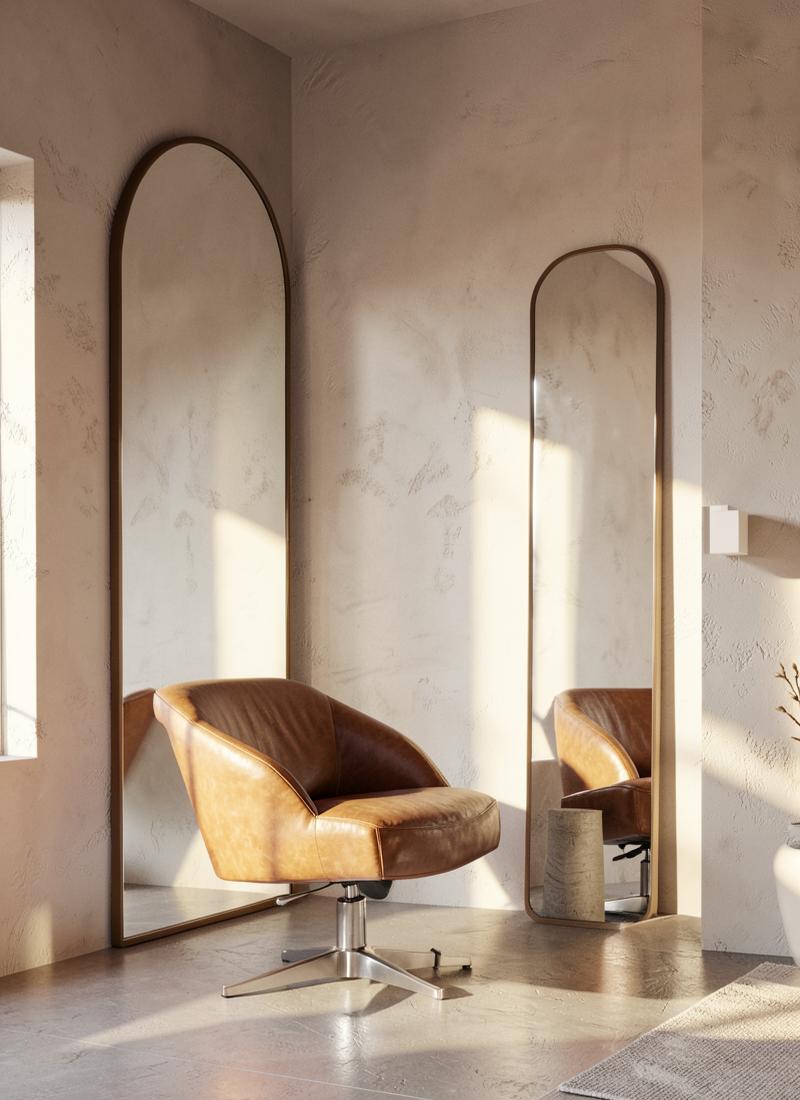 Poltrona in pelle accanto a uno specchio ad arco in una sala minimale